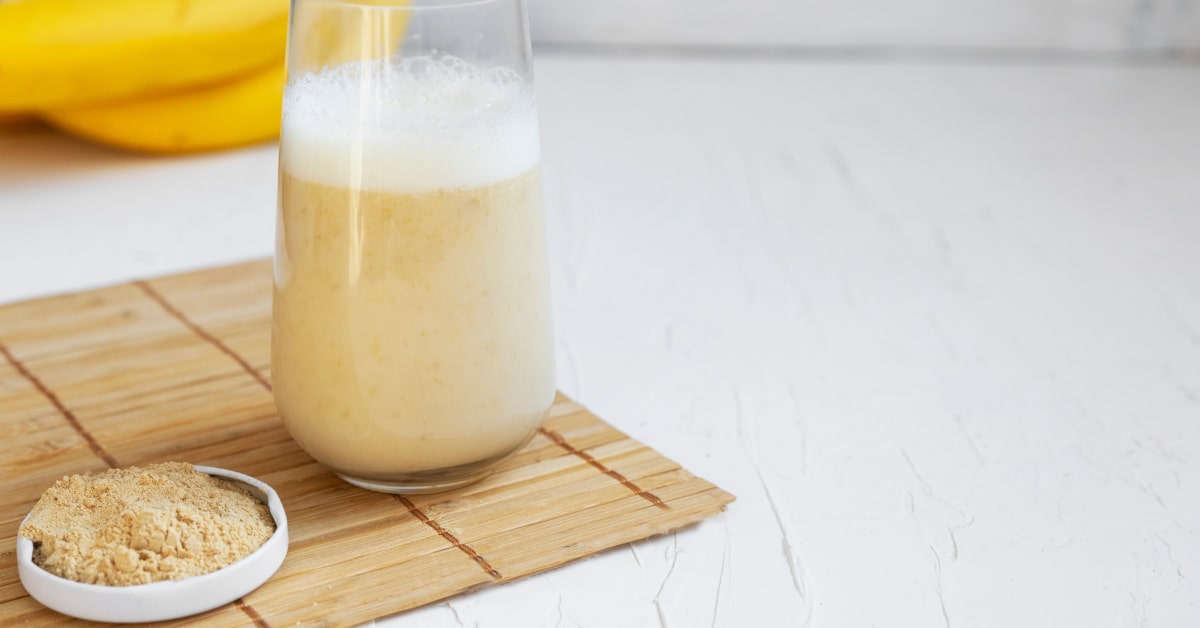 Bicchiere con caff&egrave; di maca e polvere di maca in un piattino