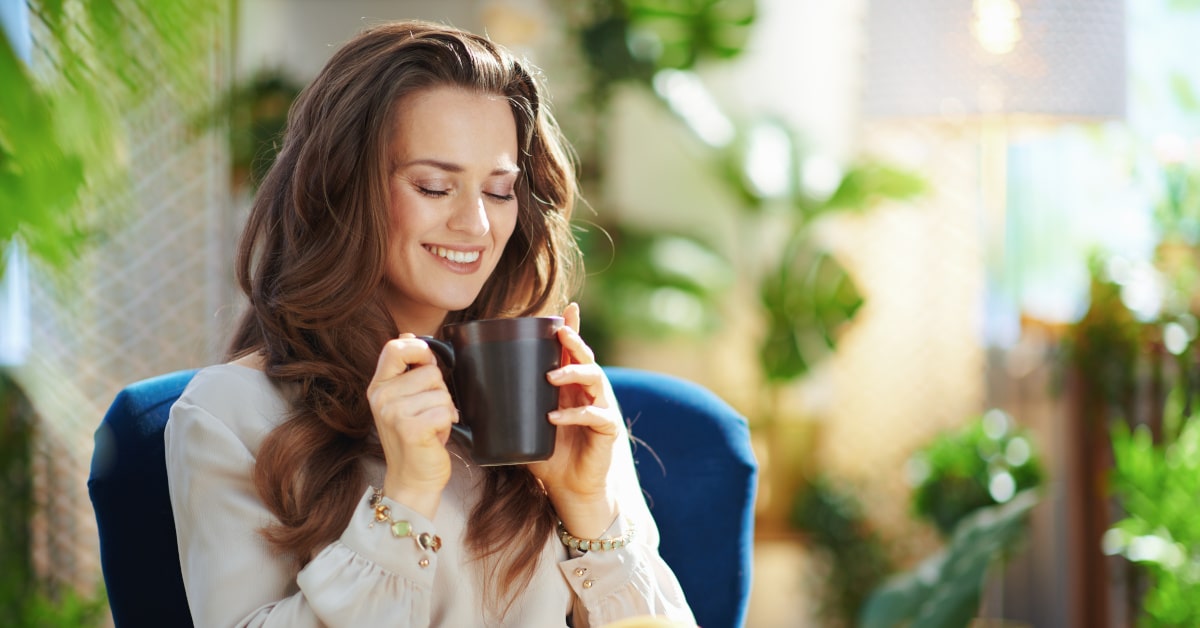 Donna in poltrona che beve una tazza di rooibos
